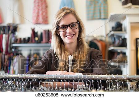 Stock Photography - Women leaning on clothes rail. Fotosearch