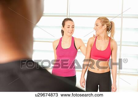 Stock Image - Women standing together in exercise class. Fotosearch