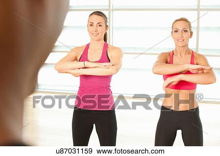 Stock Photo - Women standing together in exercise class. Fotosearch