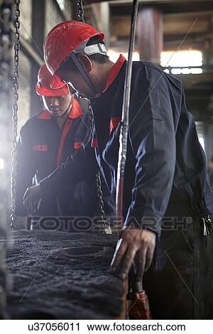 Stock Image - Working in cast iron foundry. Fotosearch
