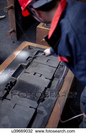 Stock Image - Working in cast iron foundry. Fotosearch