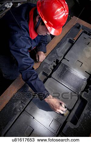 Stock Image - Working in cast iron foundry. Fotosearch
