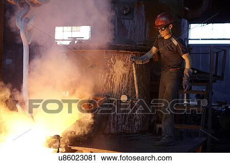 Stock Image - Working in cast iron foundry. Fotosearch