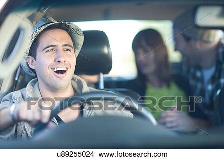 Picture - Young adult friends driving in car. Fotosearch