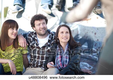 Young adult friends in front of graffiti View Large Photo Image Stock Photograph - Young adult friends in front of graffiti. Fotosearch