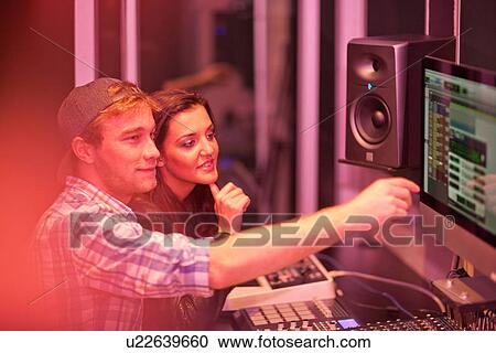 Stock Image - Young adults in college recording studio. Fotosearch