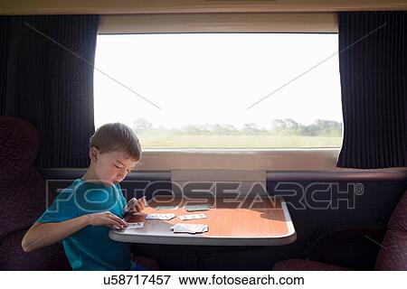 Young boy with playing cards on train View Large Photo Image Stock Photo - Young boy with playing cards on train. Fotosearch