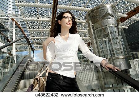 Young businesswoman on escalator View Large Photo Image Stock Image - Young businesswoman on escalator. Fotosearch