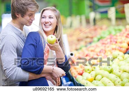 Young couple buying fruit in indoor market View Large Photo Image Stock Photography - Young couple buying fruit in indoor market. Fotosearch