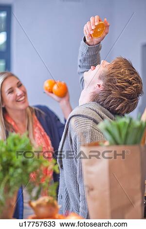 Stock Image - Young couple messing around in kitchen. Fotosearch