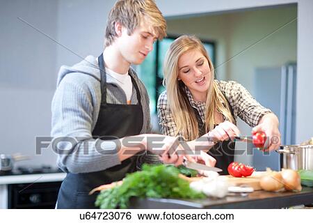 Stock Photograph - Young couple preparing meal. Fotosearch