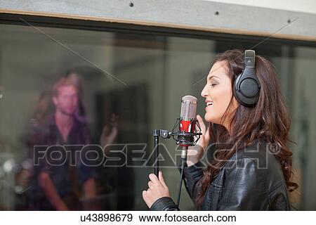 Young female singer in recording studio View Large Photo Image Stock Photo - Young female singer in recording studio. Fotosearch