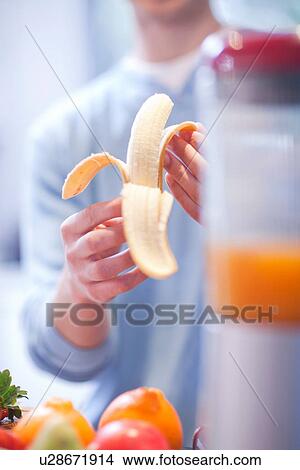 Young man peeling banana for fruit drink View Large Photo Image Picture - Young man peeling banana for fruit drink. Fotosearch