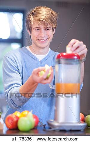 Young man preparing fruit drink View Large Photo Image Stock Image - Young man preparing fruit drink. Fotosearch