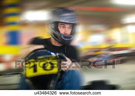 Young man racing in go cart View Large Photo Image Stock Photograph - Young man racing in go cart. Fotosearch
