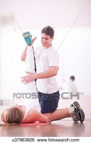 Young man training with client in gym View Large Photo Image Stock Photograph - Young man training with client in gym. Fotosearch