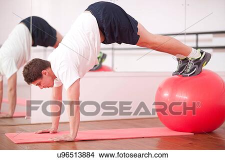 Young man training with exercise ball View Large Photo Image Picture - Young man training with exercise ball. Fotosearch