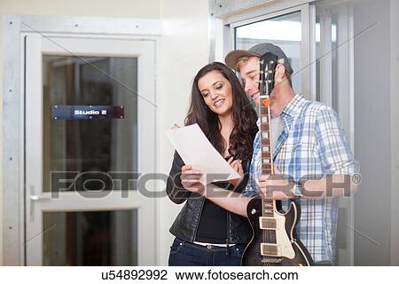 Stock Image - Young musicians looking at sheet music. Fotosearch