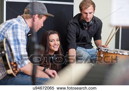 Stock Photography - Young musicians taking a break in recording studio. Fotosearch