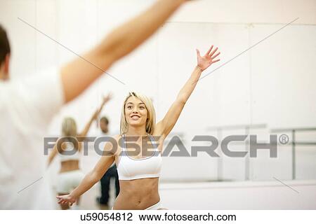 Stock Image - Young woman aerobic training in gym. Fotosearch
