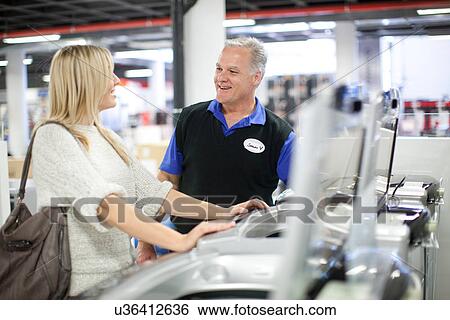 Young woman and salesman negotiating in showroom View Large Photo Image Stock Photograph - Young woman and salesman negotiating in showroom. Fotosearch