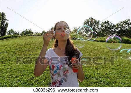 Young woman blowing bubbles View Large Photo Image Stock Photograph - Young woman blowing bubbles. Fotosearch