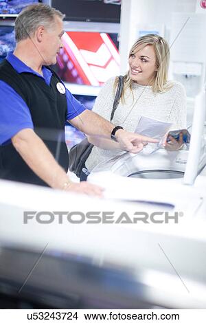 Young woman browsing washing machines in showroom View Large Photo Image Picture - Young woman browsing washing machines in showroom. Fotosearch