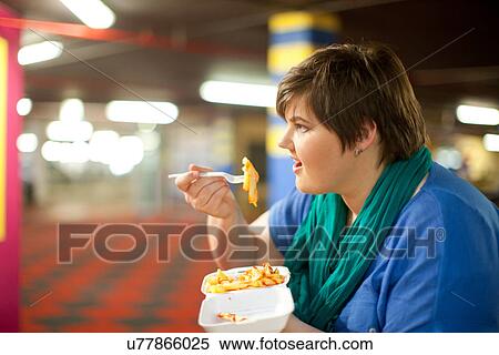 Young woman eating takeaway fries View Large Photo Image Stock Photography - Young woman eating takeaway fries. Fotosearch
