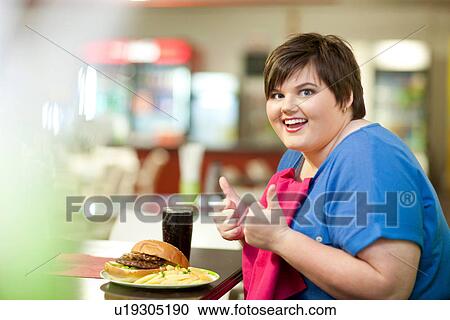 Young woman in cafe with unhealthy meal View Large Photo Image Stock Image - Young woman in cafe with unhealthy meal. Fotosearch