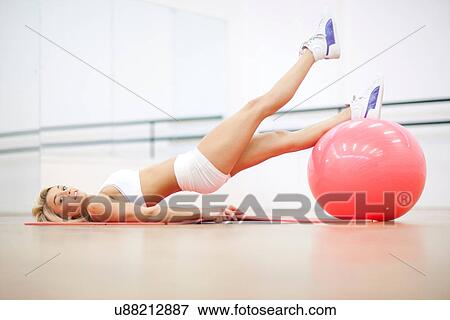 Young woman in gym training with exercise ball View Large Photo Image Stock Photo - Young woman in gym training with exercise ball. Fotosearch