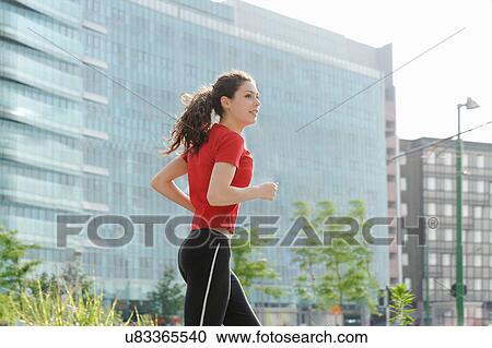 Young woman jogging in city View Large Photo Image Stock Image - Young woman jogging in city. Fotosearch