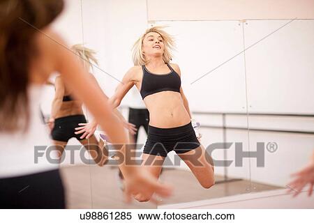 Young woman jumping in aerobics class View Large Photo Image Stock Photography - Young woman jumping in aerobics class. Fotosearch