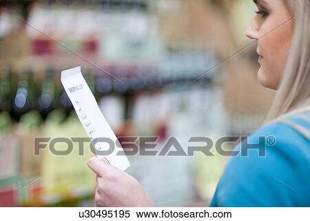 Young woman looking at shopping list in supermarket View Large Photo Image Stock Photography - Young woman looking at shopping list in supermarket. Fotosearch