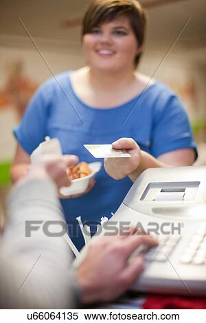 Young woman paying for takeaway order in cafe View Large Photo Image Stock Photography - Young woman paying for takeaway order in cafe. Fotosearch