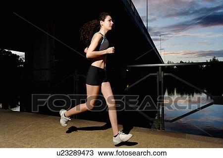 Young woman running at sunset View Large Photo Image Stock Image - Young woman running at sunset. Fotosearch