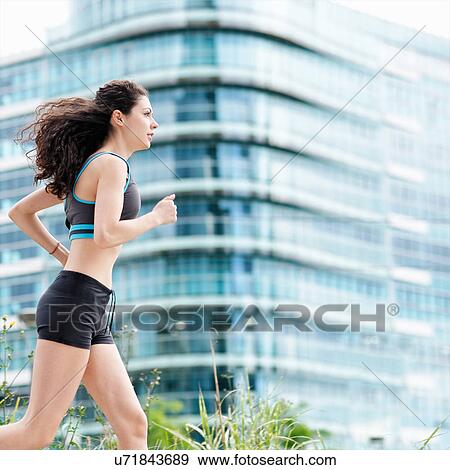 Young woman running in city View Large Photo Image Stock Photo - Young woman running in city. Fotosearch