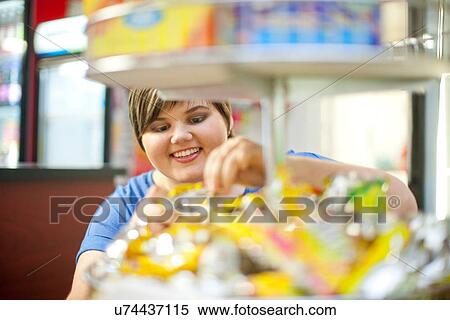 Young woman selecting confectionary in cafe View Large Photo Image Stock Photography - Young woman selecting confectionary in cafe. Fotosearch