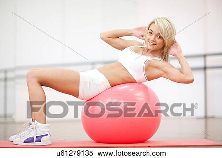 Young woman sitting on exercise ball in aerobics class View Large Photo Image Stock Photography - Young woman sitting on exercise ball in aerobics class. Fotosearch