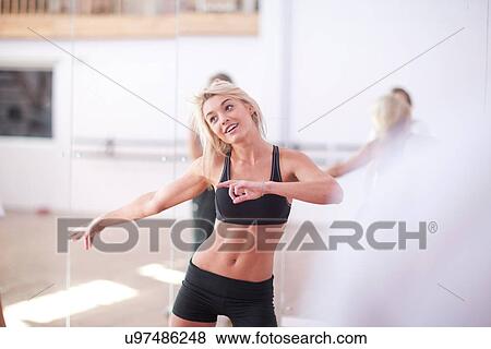 Young woman stretching in aerobic class View Large Photo Image Stock Photo - Young woman stretching in aerobic class. Fotosearch