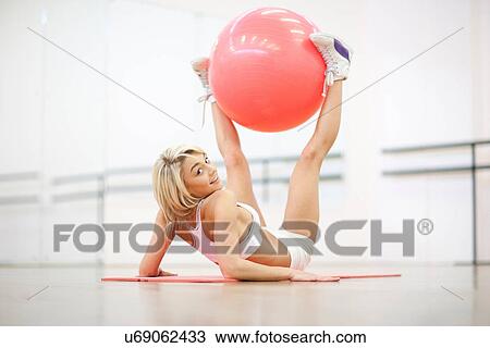 Young woman stretching with exercise ball View Large Photo Image Stock Image - Young woman stretching with exercise ball. Fotosearch
