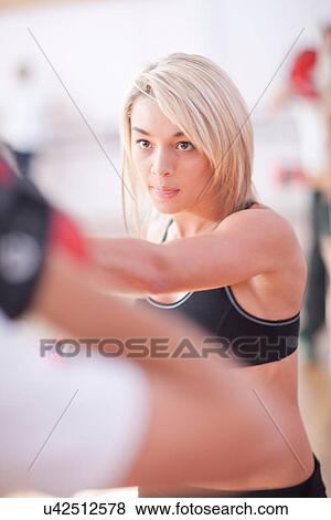 Stock Photo - Young woman training in gym. Fotosearch