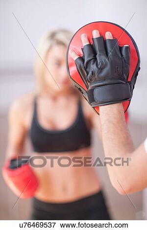 Stock Photo - Young woman training in gym. Fotosearch