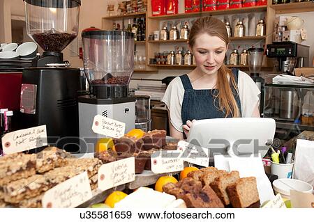 Young woman using cash register in cafe View Large Photo Image Stock Photo - Young woman using cash register in cafe. Fotosearch