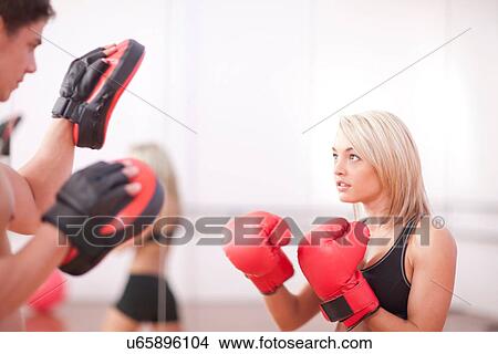 Young woman wearing boxing gloves in gym View Large Photo Image Picture - Young woman wearing boxing gloves in gym. Fotosearch