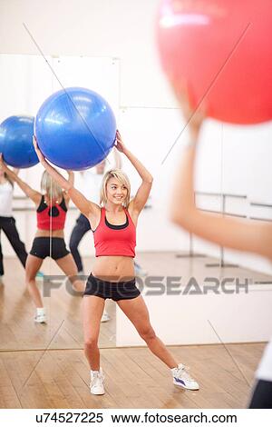 Young woman with exercise ball in aerobics class View Large Photo Image Stock Photography - Young woman with exercise ball in aerobics class. Fotosearch