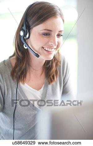 Young woman with headset on computer View Large Photo Image Stock Photo - Young woman with headset on computer. Fotosearch