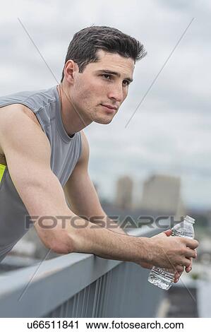 Athlete leaning against railing View Large Photo Image Stock Image - Athlete leaning against railing . Fotosearch