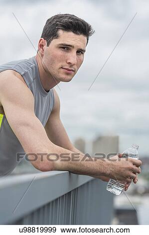 Stock Photo - Athlete leaning against railing . Fotosearch
