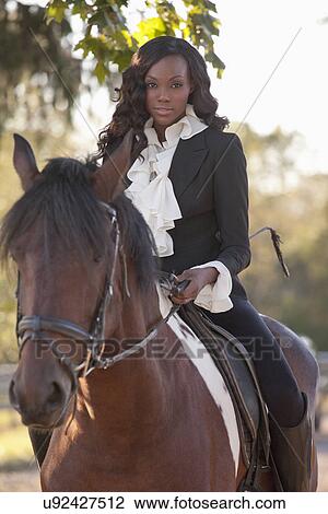Stock Image - Beautiful woman horseriding. Fotosearch