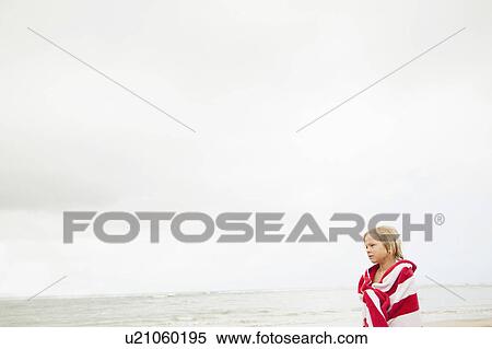 Boy (6-7) wrapped in towel on beach View Large Photo Image Stock Photography - Boy (6-7) wrapped in towel on beach. Fotosearch